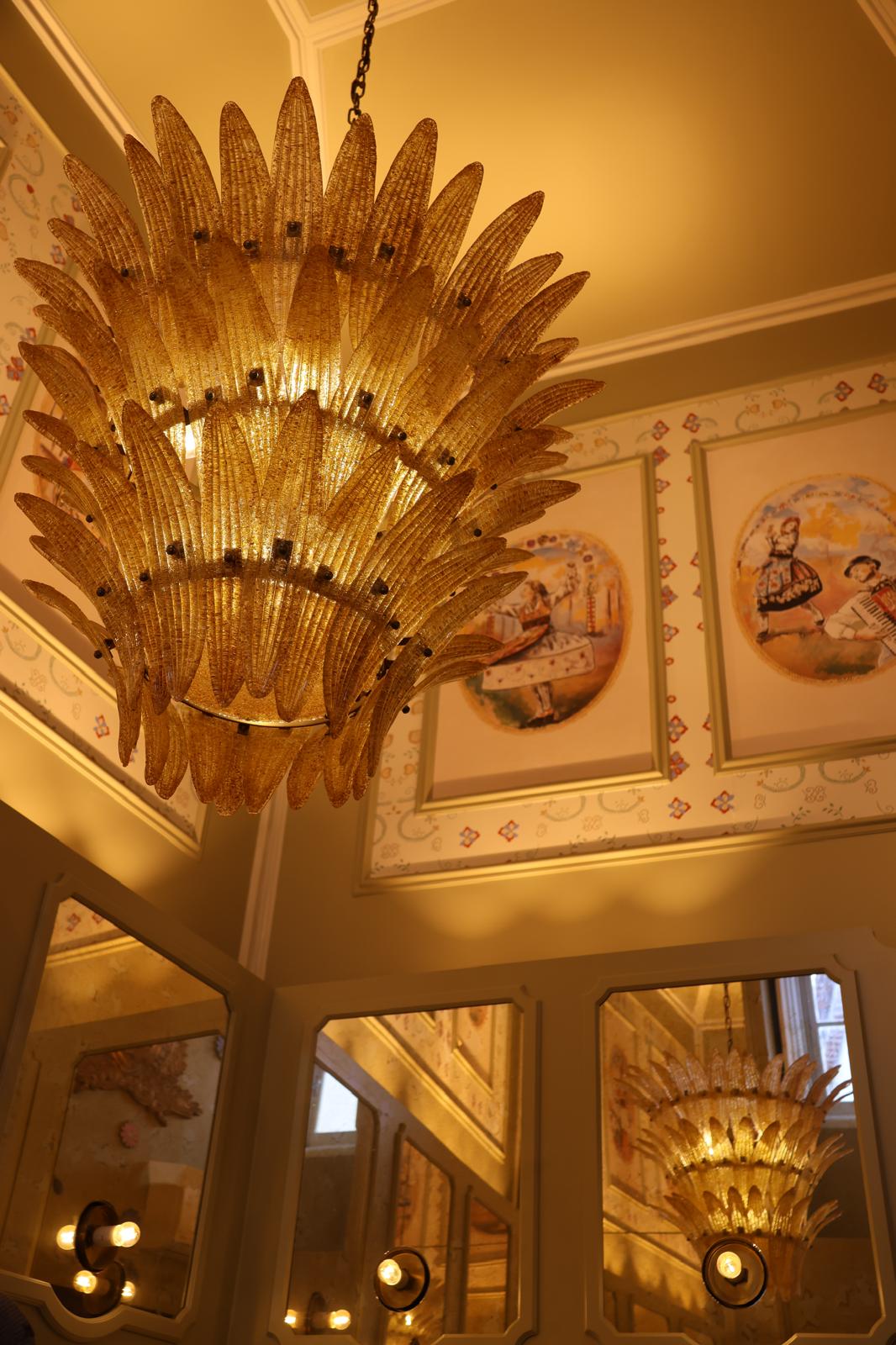 Decorative chandelier in a refined interior with mirrored walls and painted panels