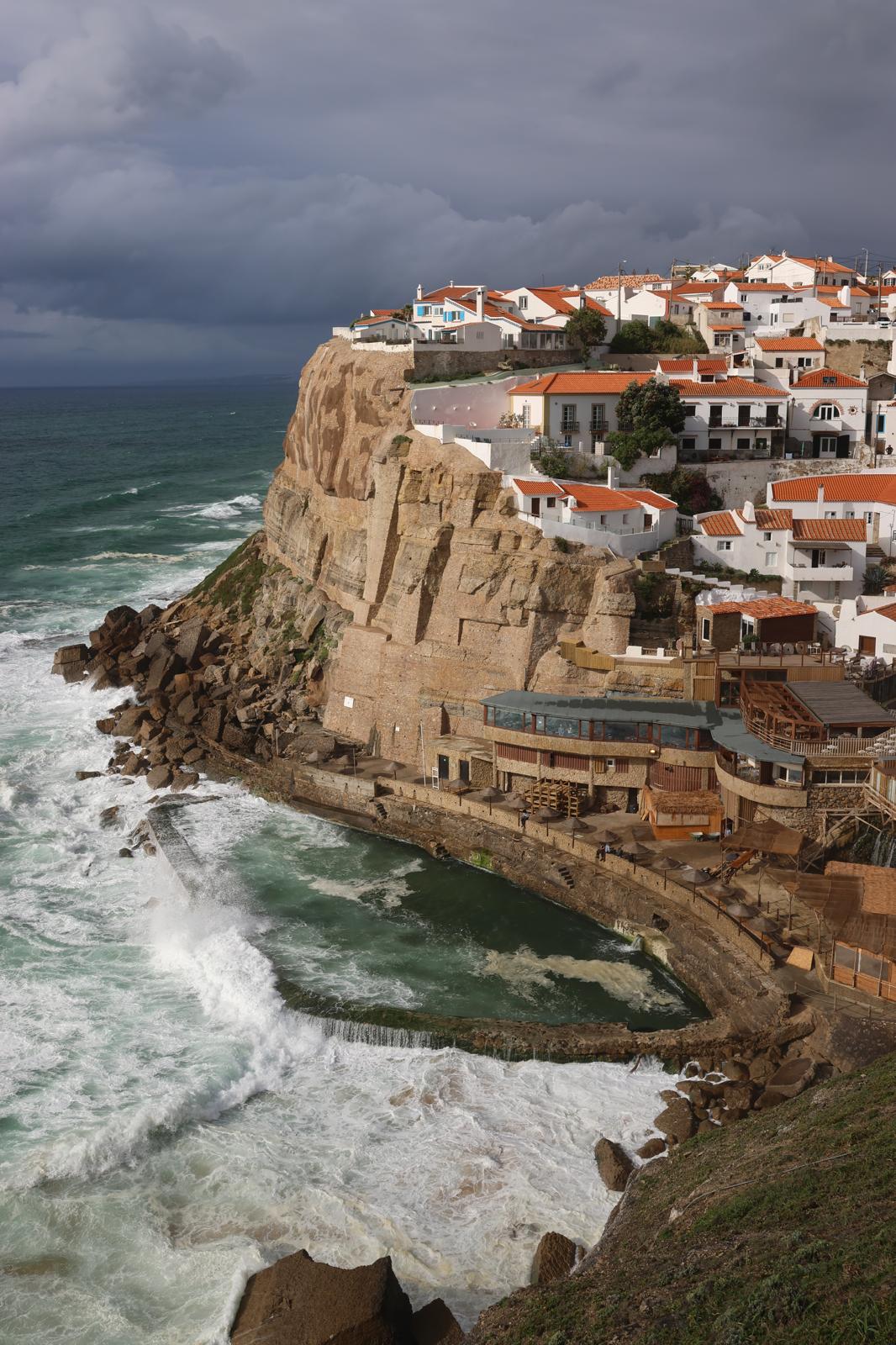 Coastal Portuguese village with cliffside homes and Atlantic waves
